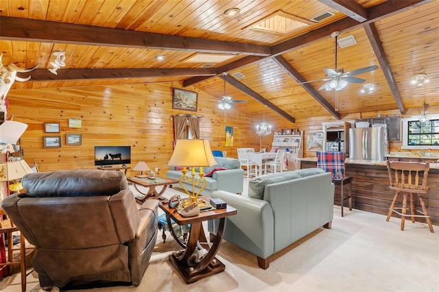 living room featuring wood walls, ceiling fan, and lofted ceiling with skylight