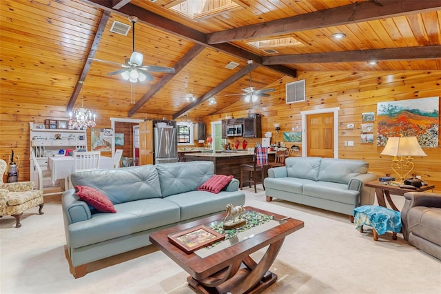 carpeted living room featuring wooden walls, lofted ceiling with skylight, and wood ceiling