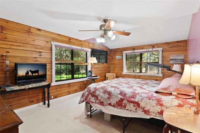 carpeted bedroom with ceiling fan, wood walls, lofted ceiling, and multiple windows