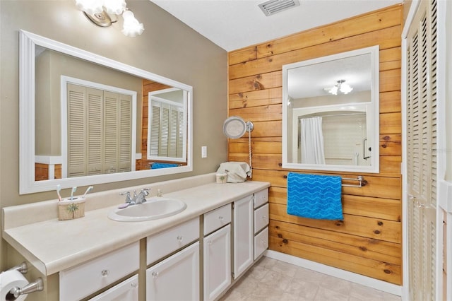 bathroom with wood walls and vanity