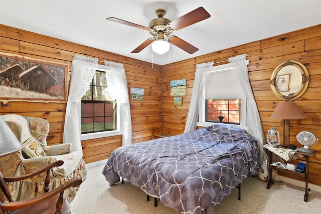 bedroom featuring ceiling fan, carpet, and wood walls