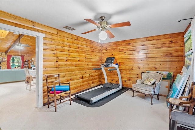 exercise area with light colored carpet, rustic walls, and ceiling fan