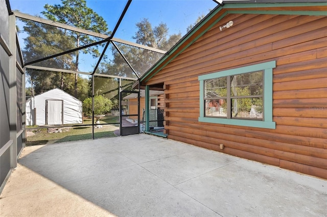 view of patio / terrace with a lanai and a shed