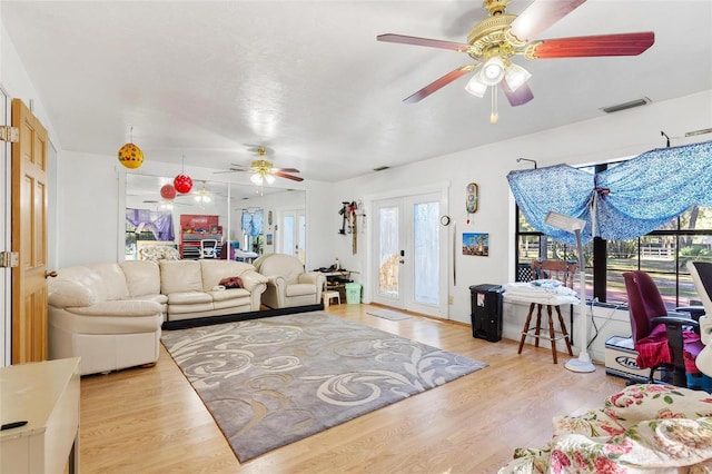 living room with ceiling fan, light hardwood / wood-style flooring, and french doors