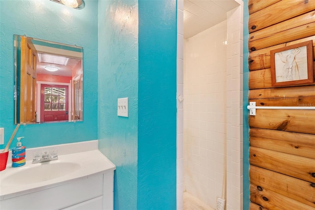 bathroom featuring rustic walls and vanity