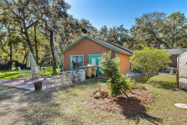 back of property featuring a patio area and a yard