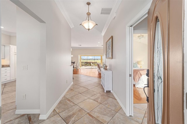 hall with light tile patterned floors, baseboards, visible vents, and ornamental molding