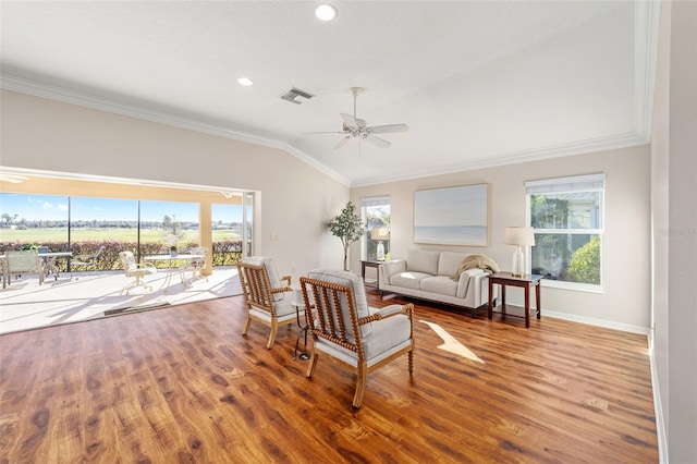 living area with lofted ceiling, visible vents, crown molding, and wood finished floors