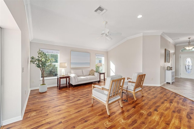 interior space with ornamental molding, a wealth of natural light, visible vents, and wood finished floors