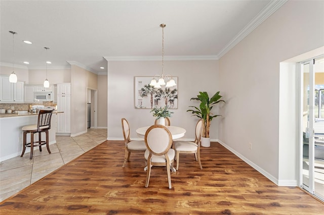 dining space featuring crown molding, baseboards, and a notable chandelier