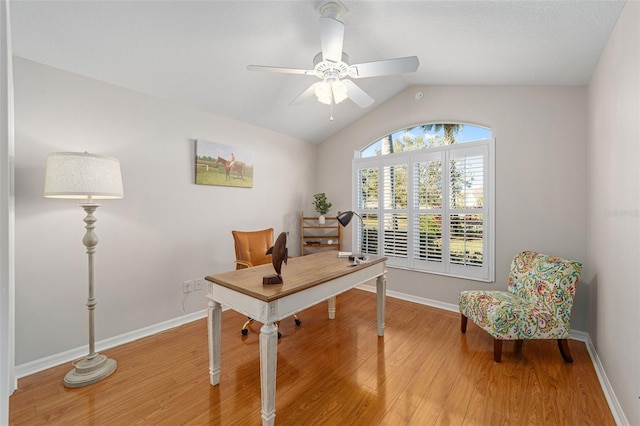 office space with lofted ceiling, ceiling fan, wood finished floors, and baseboards