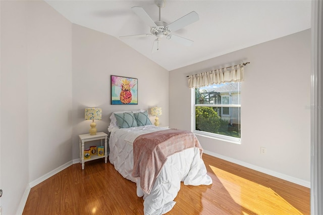 bedroom featuring a ceiling fan, baseboards, vaulted ceiling, and wood finished floors