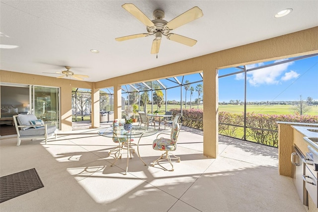 sunroom with a healthy amount of sunlight and ceiling fan