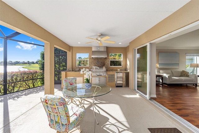 sunroom / solarium featuring a ceiling fan and a sink