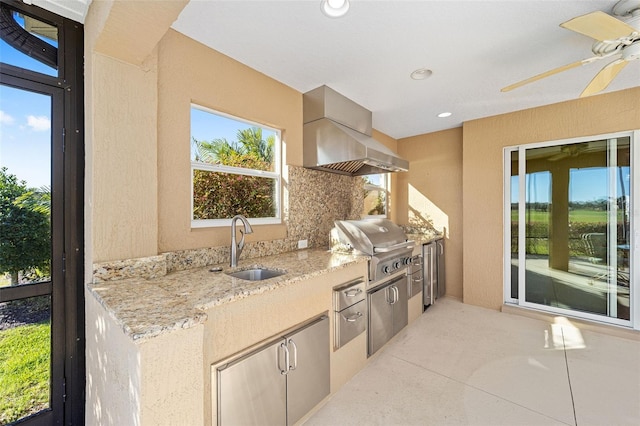 kitchen featuring light stone counters, extractor fan, recessed lighting, a sink, and backsplash