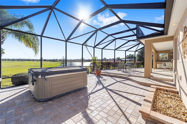 view of patio / terrace featuring a lanai and a hot tub