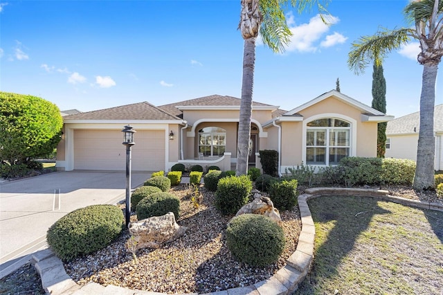 ranch-style house with a garage, concrete driveway, and stucco siding