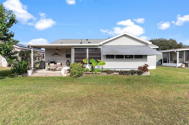 rear view of property with a yard, ceiling fan, a patio area, and a sunroom