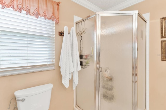 bathroom featuring toilet, a shower with door, and ornamental molding