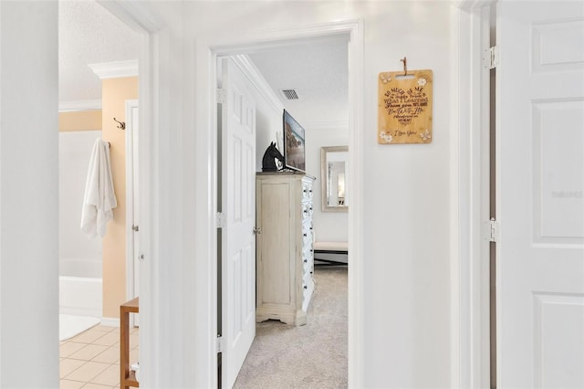 hallway with crown molding, light colored carpet, and a textured ceiling