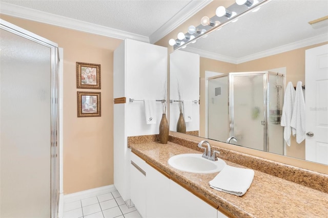 full bath with tile patterned flooring, vanity, ornamental molding, a stall shower, and a textured ceiling