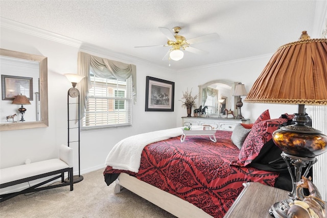 carpeted bedroom with a textured ceiling, a ceiling fan, baseboards, and ornamental molding