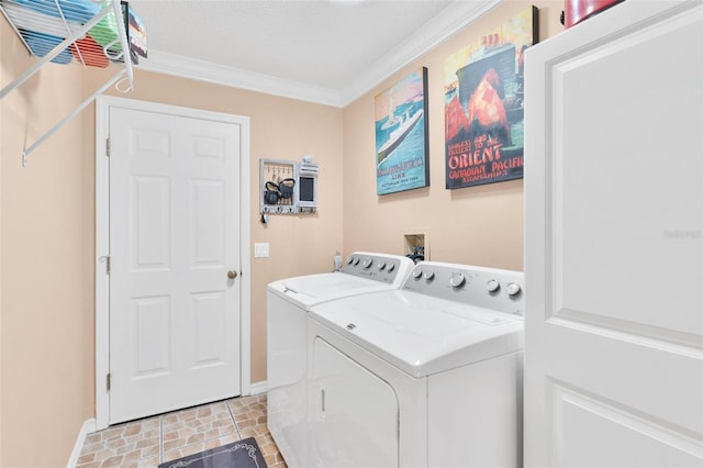 washroom featuring baseboards, ornamental molding, laundry area, and washer and clothes dryer