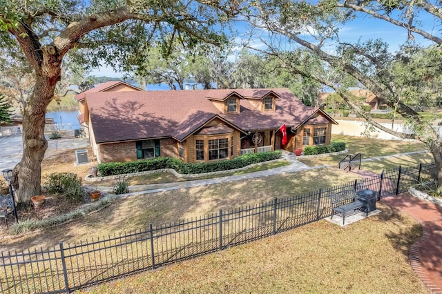 english style home with a water view and a front yard