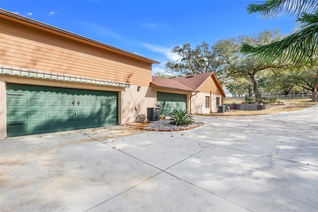 view of front of property featuring a garage and central air condition unit