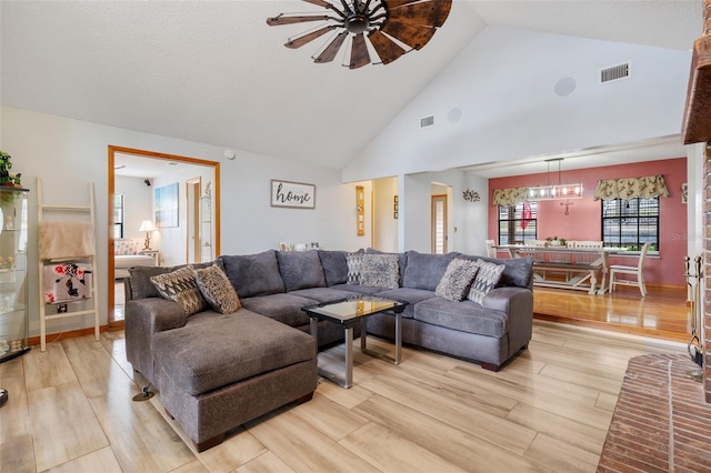 living room featuring high vaulted ceiling and light hardwood / wood-style flooring