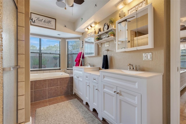 bathroom featuring ceiling fan, tile patterned flooring, a relaxing tiled tub, vanity, and decorative backsplash