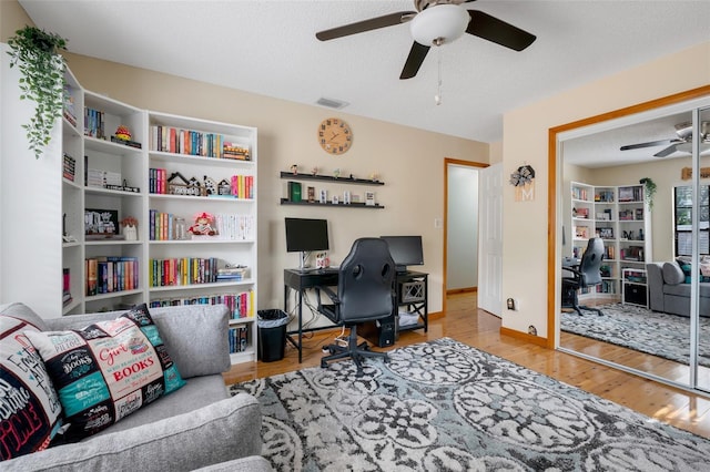 office area featuring ceiling fan, light hardwood / wood-style floors, and a textured ceiling