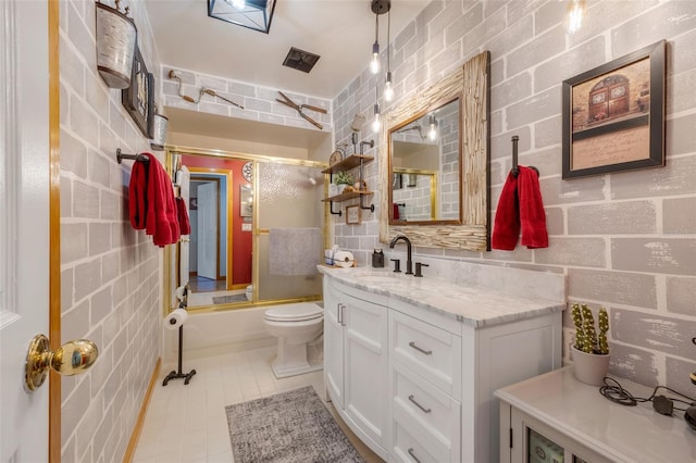 full bathroom featuring enclosed tub / shower combo, vanity, toilet, and tile patterned flooring