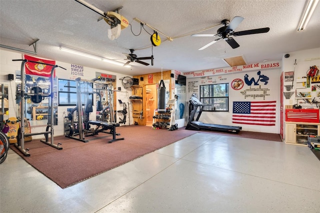 gym featuring ceiling fan and a textured ceiling