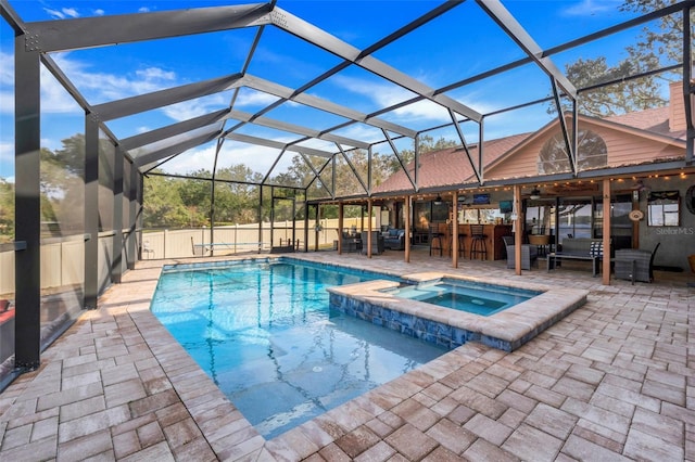 view of swimming pool featuring a patio area, an in ground hot tub, glass enclosure, and exterior bar