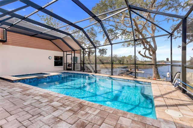 view of swimming pool featuring an in ground hot tub, a water view, glass enclosure, and a patio