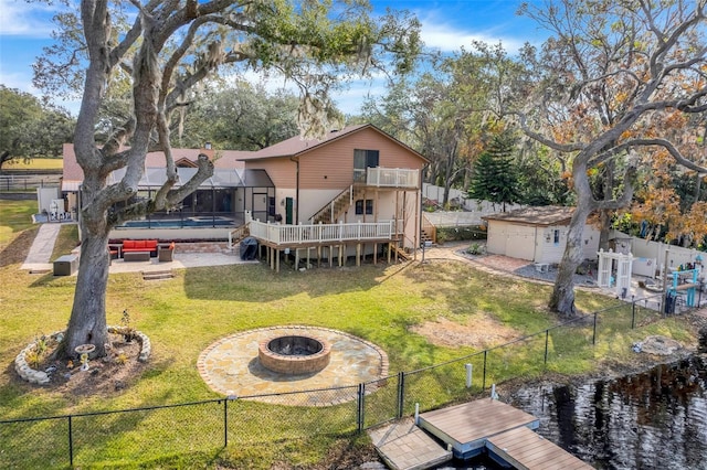 rear view of property featuring a yard, a patio area, a shed, and a fire pit