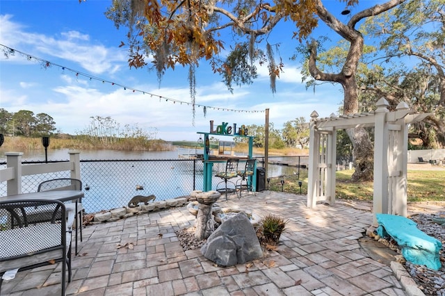 view of patio featuring a pergola and a water view