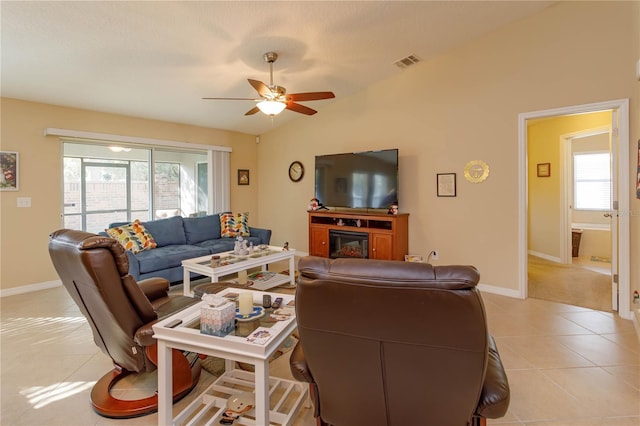 living room with light tile patterned floors, a wealth of natural light, lofted ceiling, and ceiling fan