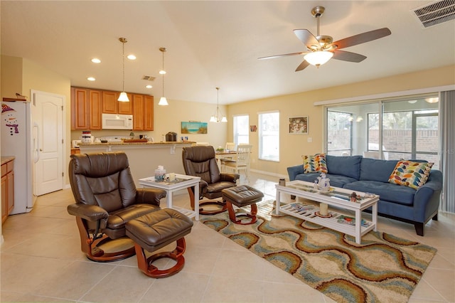 living room with ceiling fan, light tile patterned flooring, and lofted ceiling