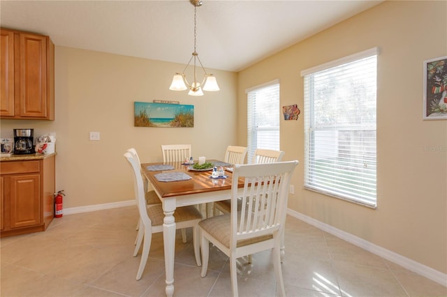 tiled dining area featuring a notable chandelier