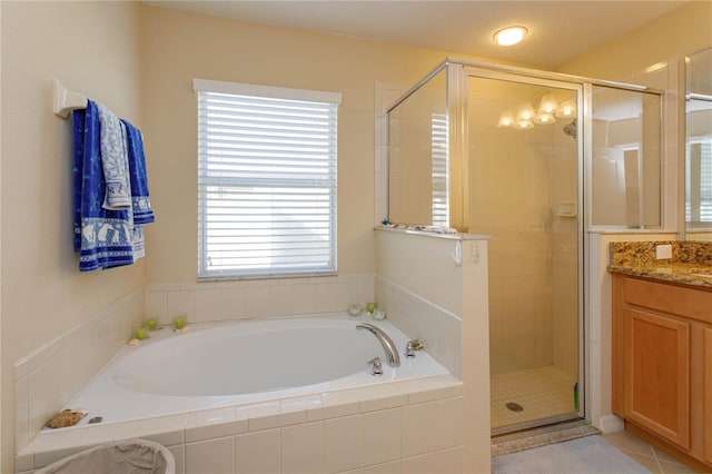 bathroom with tile patterned flooring, vanity, independent shower and bath, and a wealth of natural light