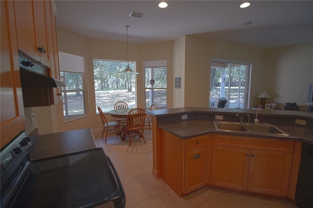 kitchen with kitchen peninsula, sink, black appliances, light tile patterned floors, and decorative light fixtures