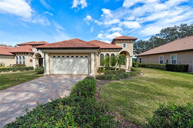 mediterranean / spanish-style house with a garage and a front yard