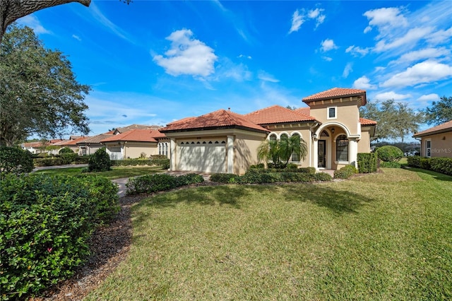 mediterranean / spanish-style house featuring a garage and a front lawn