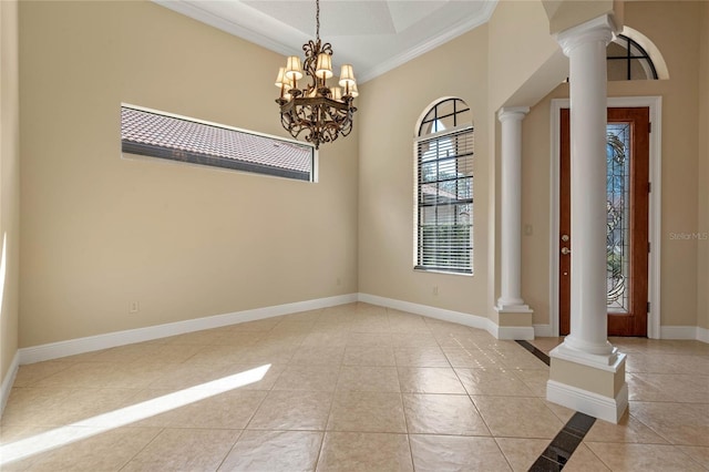 foyer with decorative columns, light tile patterned flooring, ornamental molding, and a chandelier