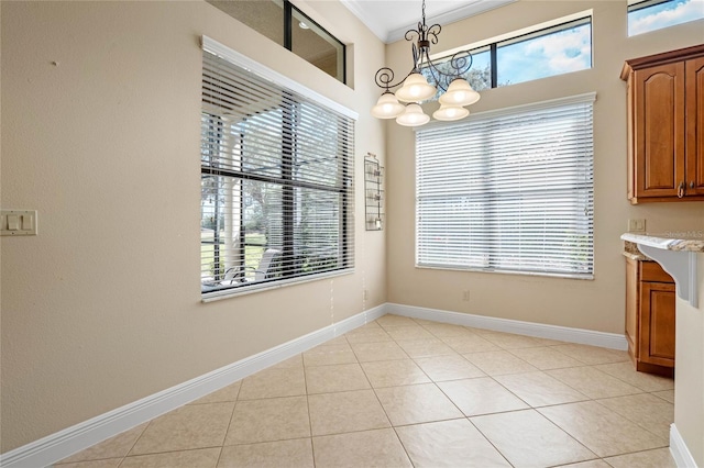 unfurnished dining area featuring light tile patterned flooring, crown molding, and an inviting chandelier