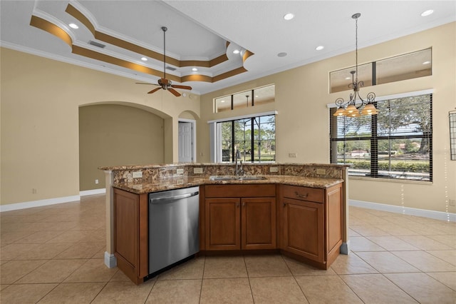 kitchen with sink, light stone counters, ornamental molding, dishwasher, and a raised ceiling