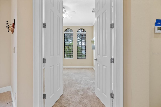 corridor featuring light carpet and ornamental molding