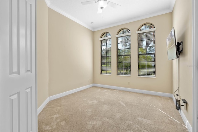 empty room with crown molding, light colored carpet, and ceiling fan